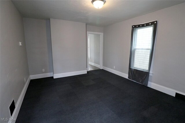 unfurnished room with baseboards