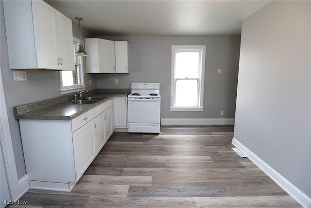 kitchen featuring a sink, baseboards, white range with electric stovetop, and white cabinetry