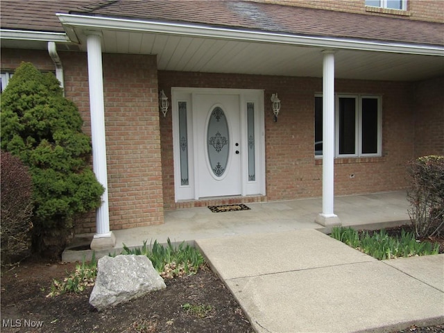 230 Bryden Rd, Weirton, WV 26062 - doorway to property featuring a shingled roof, covered porch, and brick siding