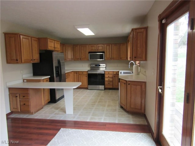 230 Bryden Rd, Weirton, WV 26062 - kitchen with a sink, light countertops, a peninsula, light wood finished floors, and stainless steel appliances