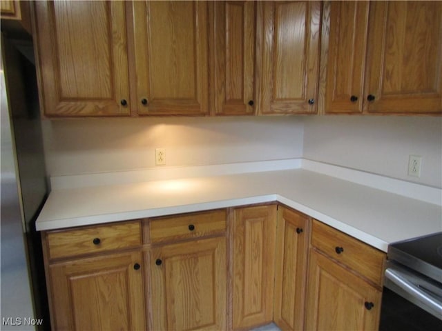 230 Bryden Rd, Weirton, WV 26062 - kitchen featuring brown cabinetry, light countertops, and freestanding refrigerator