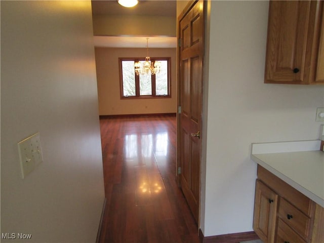 230 Bryden Rd, Weirton, WV 26062 - hallway featuring dark wood-style flooring, a notable chandelier, and baseboards