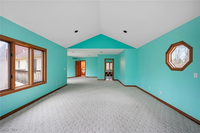 empty room with baseboards, vaulted ceiling, and carpet floors