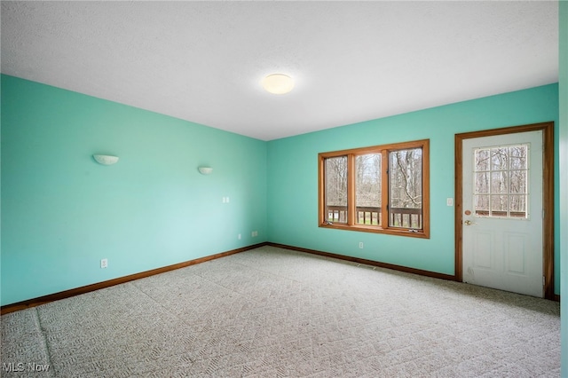 unfurnished room with baseboards and carpet floors