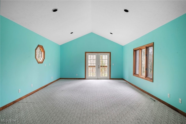 carpeted empty room featuring baseboards, vaulted ceiling, and visible vents