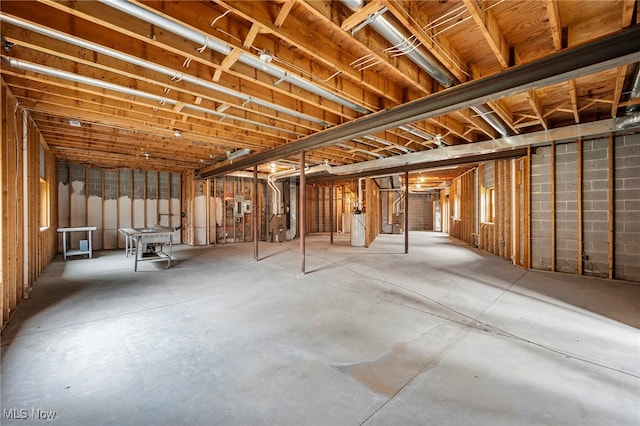 unfinished basement featuring water heater and heating unit