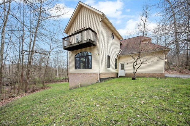 exterior space featuring a lawn and a balcony