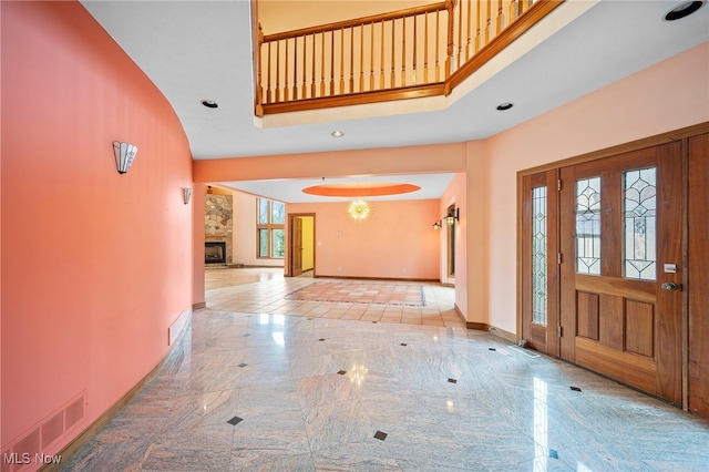 entryway featuring baseboards, a high ceiling, visible vents, arched walkways, and marble finish floor