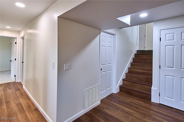 stairway featuring recessed lighting, wood finished floors, visible vents, and baseboards