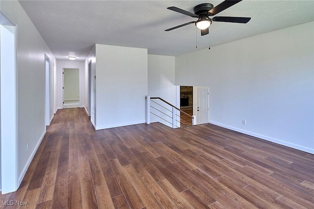 empty room with dark wood finished floors, baseboards, and a ceiling fan