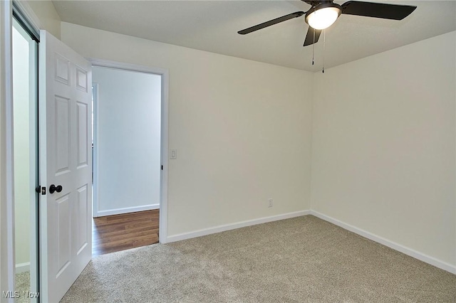empty room featuring carpet floors, a ceiling fan, and baseboards