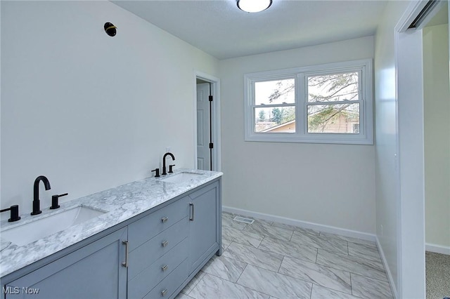 laundry area featuring baseboards and a sink
