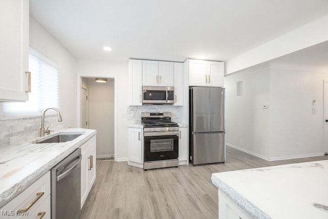 15304 Bartlett Ave, Cleveland, OH 44120 - kitchen featuring appliances with stainless steel finishes, a sink, decorative backsplash, light wood-style flooring, and recessed lighting