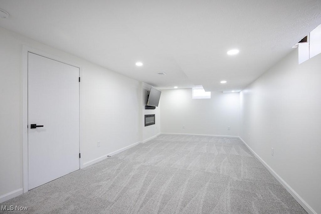 below grade area with baseboards, recessed lighting, and light colored carpet