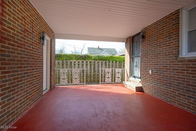 view of patio featuring an attached carport and fence
