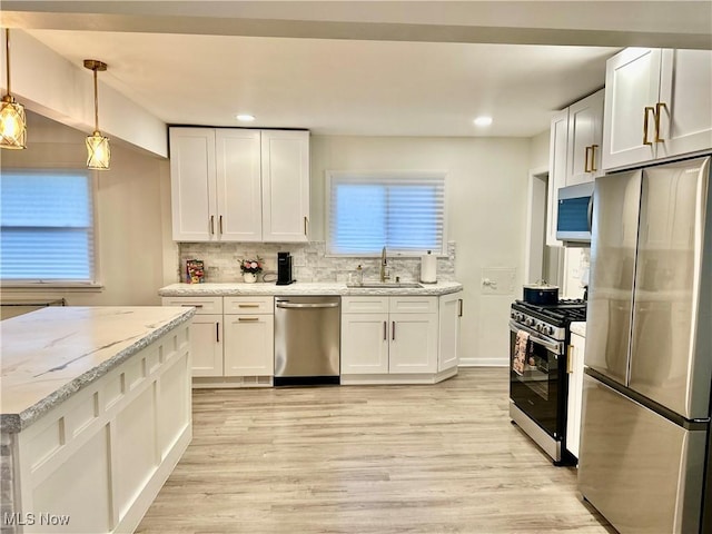 15304 Bartlett Ave, Cleveland, OH 44120 - kitchen with appliances with stainless steel finishes, a sink, light wood-style floors, white cabinetry, and recessed lighting