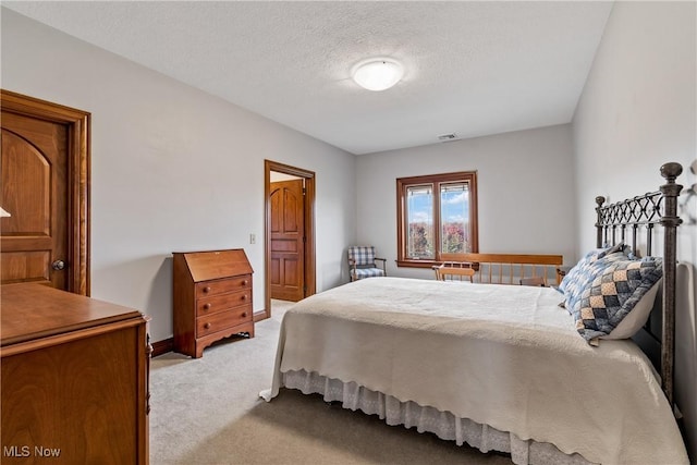 2142 State St NW, Uniontown, OH 44685 - bedroom with a textured ceiling, light colored carpet, and visible vents