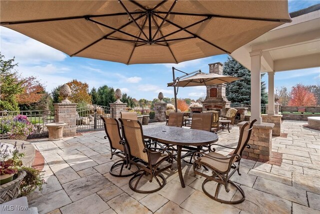 2142 State St NW, Uniontown, OH 44685 - view of patio featuring outdoor dining space, fence, and an outdoor stone fireplace