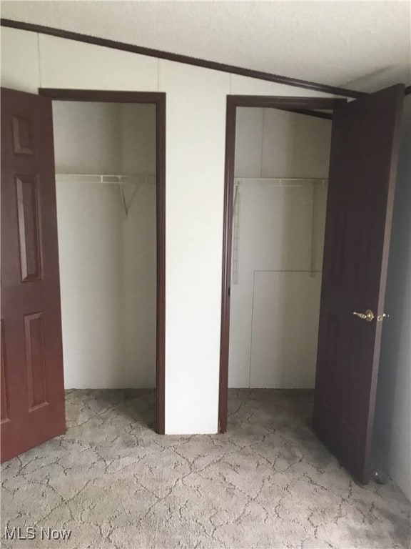 unfurnished bedroom featuring multiple closets