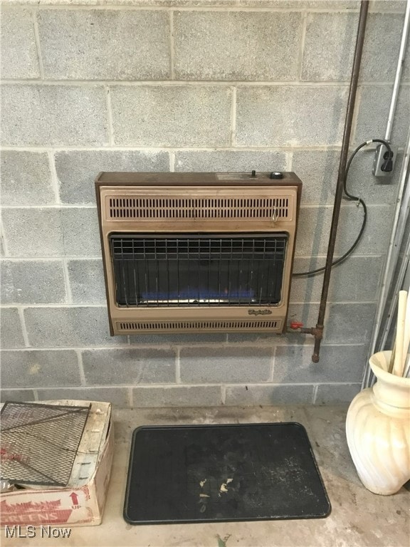 details featuring heating unit and concrete block wall