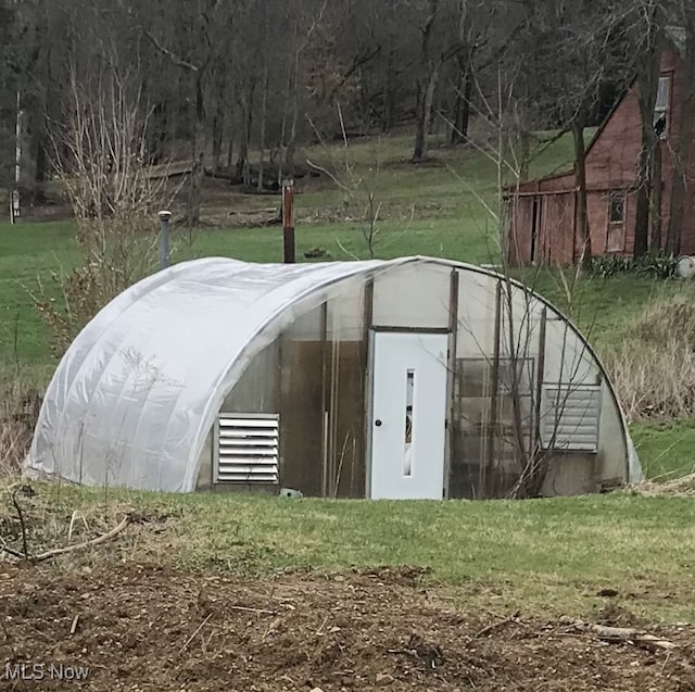 view of greenhouse with a yard