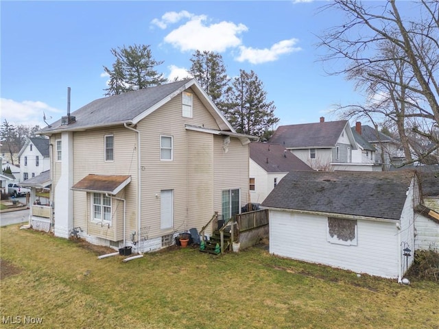 back of property with an outbuilding and a lawn
