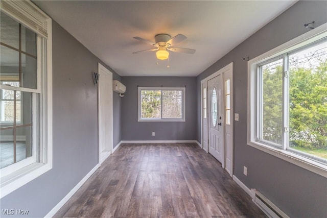 foyer entrance featuring baseboards, dark wood-style flooring, an AC wall unit, a baseboard radiator, and ceiling fan