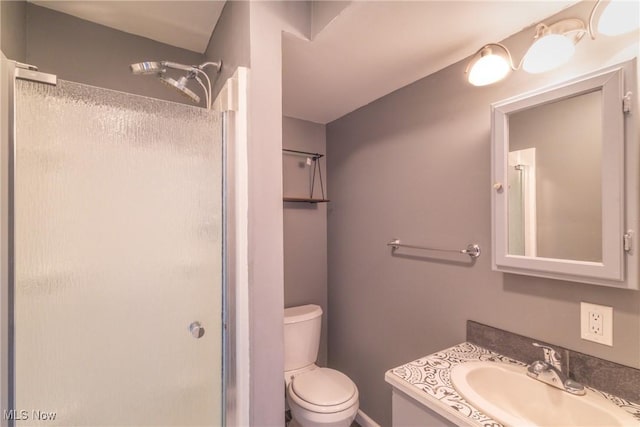 full bath featuring toilet, vanity, and a stall shower