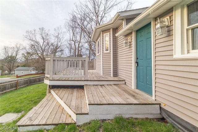wooden deck featuring fence and a lawn