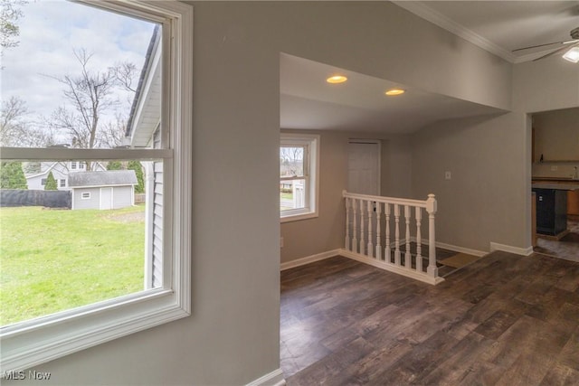 interior space featuring wood finished floors, baseboards, and a ceiling fan