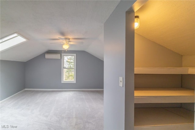 additional living space featuring a wall mounted air conditioner, lofted ceiling, baseboards, and carpet floors