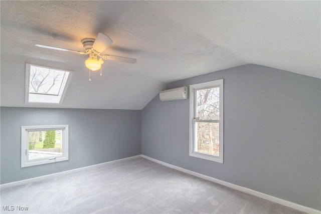 bonus room with a ceiling fan, vaulted ceiling, light carpet, a wall mounted air conditioner, and baseboards