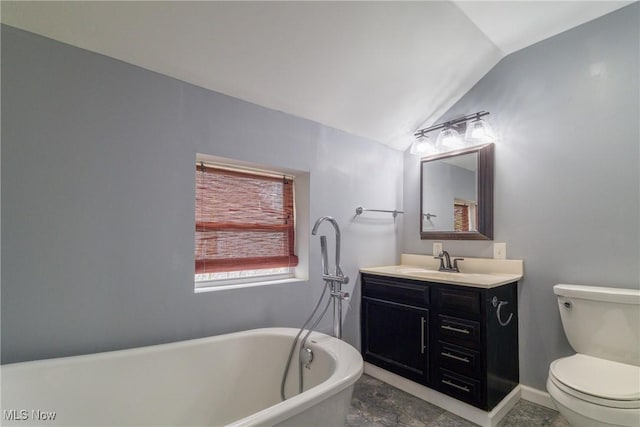 bathroom featuring a freestanding tub, vanity, toilet, lofted ceiling, and baseboards