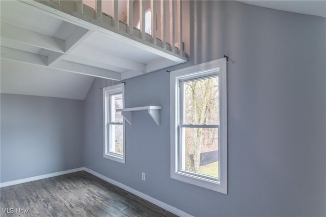 additional living space with wood finished floors, baseboards, vaulted ceiling with beams, and plenty of natural light