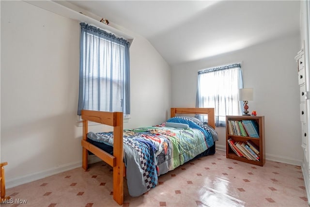 bedroom with baseboards, tile patterned floors, and lofted ceiling