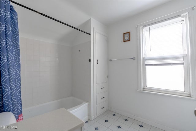 bathroom featuring tile patterned floors, baseboards, shower / bathtub combination with curtain, and a wealth of natural light