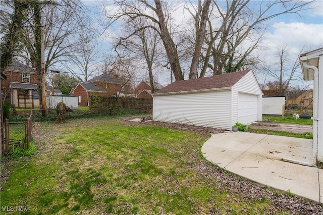 view of yard featuring an outdoor structure, fence, and a detached garage