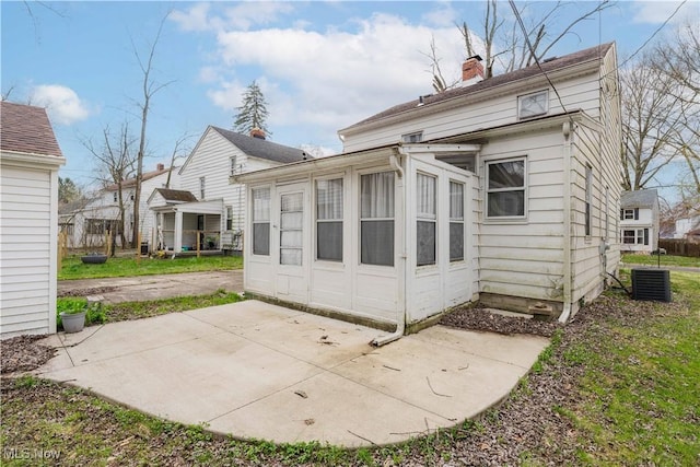 back of property with a patio, a chimney, and central AC unit