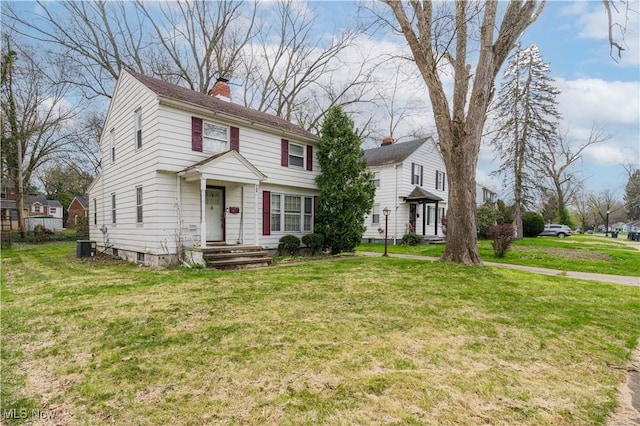 view of front of home featuring a front lawn and a chimney