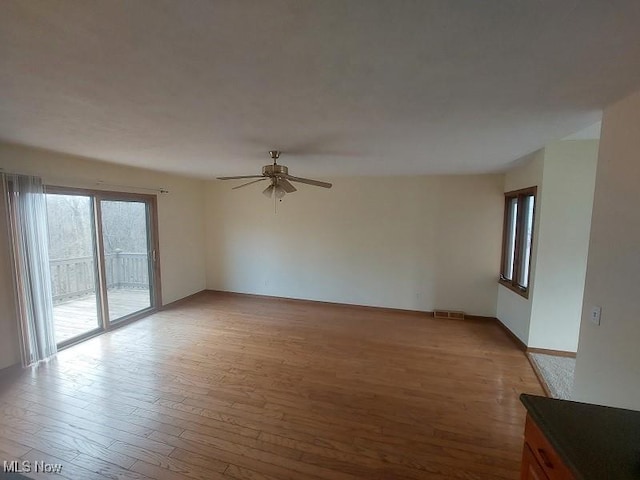 unfurnished living room with visible vents, light wood-type flooring, and ceiling fan