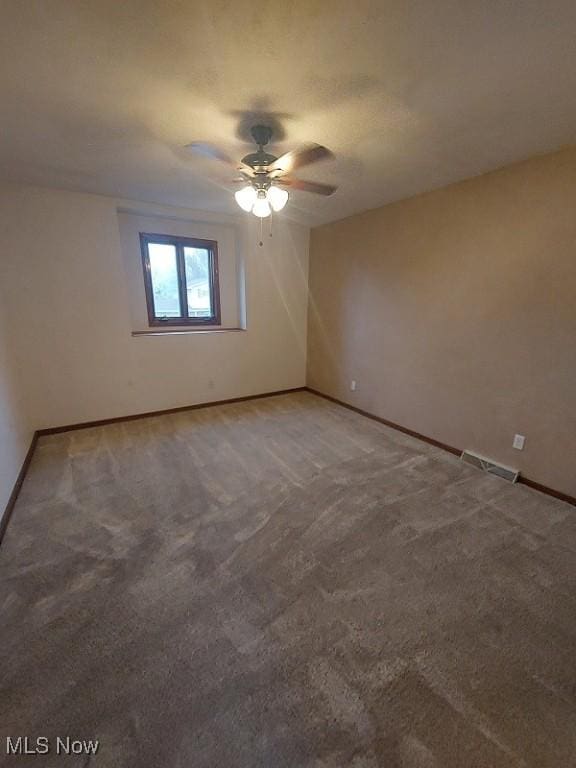 unfurnished room featuring carpet floors, baseboards, and a ceiling fan