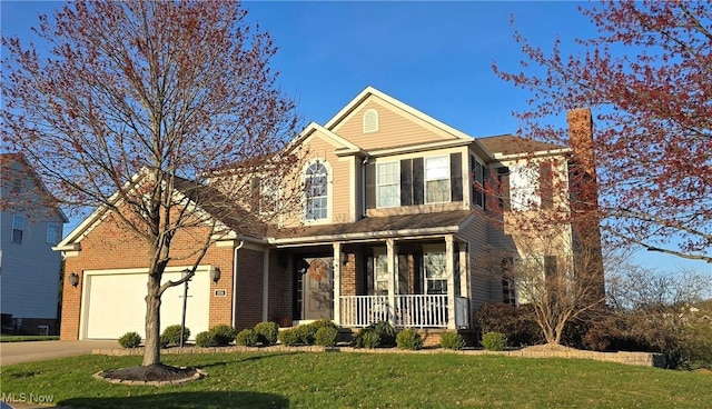 218 Canterbury Ct, Columbiana, OH 44408 - traditional-style house featuring concrete driveway, an attached garage, a front lawn, brick siding, and covered porch
