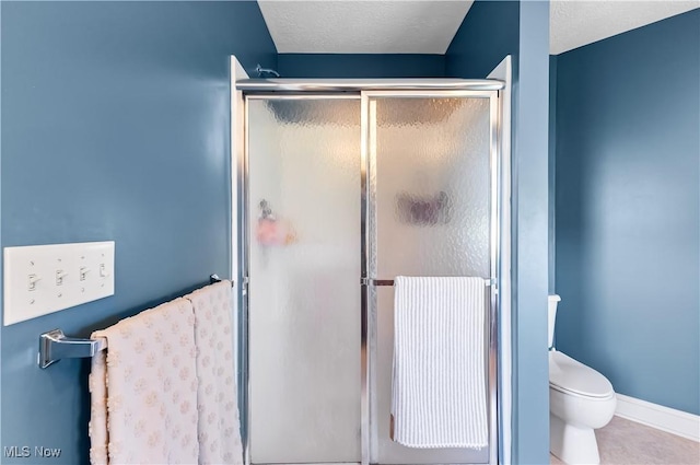 218 Canterbury Ct, Columbiana, OH 44408 - bathroom with baseboards, toilet, a textured ceiling, tile patterned flooring, and a stall shower