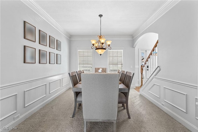218 Canterbury Ct, Columbiana, OH 44408 - dining area featuring a chandelier, arched walkways, light colored carpet, and crown molding