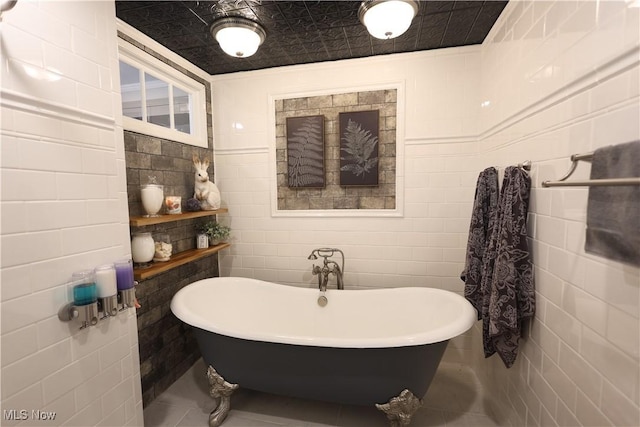 128 Center St, Milan, OH 44846 - full bath featuring tile walls, tile patterned floors, and a soaking tub