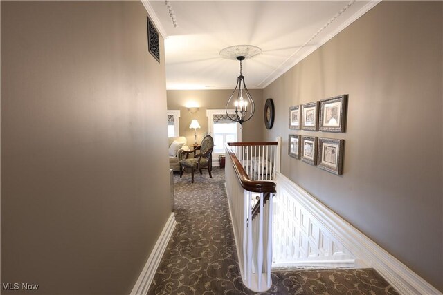 128 Center St, Milan, OH 44846 - corridor with dark carpet, crown molding, an upstairs landing, a chandelier, and visible vents