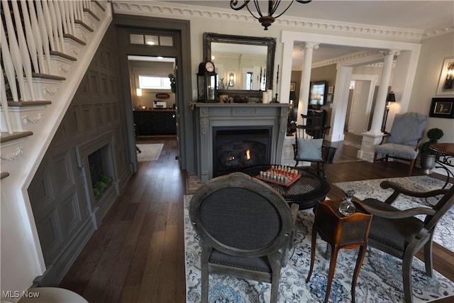 128 Center St, Milan, OH 44846 - living area with decorative columns, a lit fireplace, and dark wood-type flooring