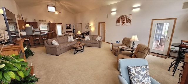 living room featuring high vaulted ceiling and light colored carpet