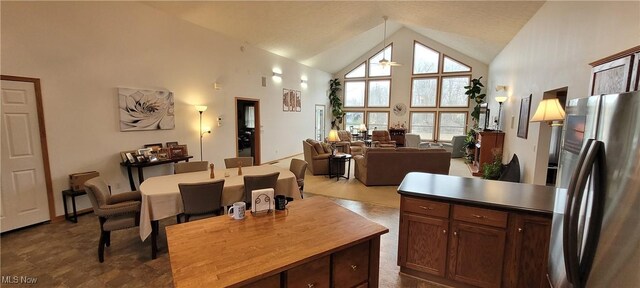 kitchen featuring high vaulted ceiling, freestanding refrigerator, and hanging light fixtures