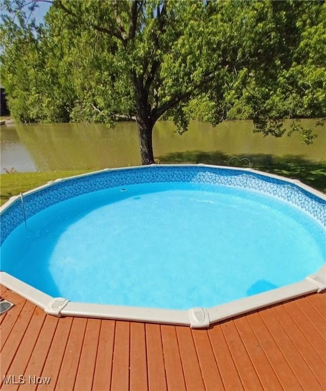 outdoor pool with a deck with water view